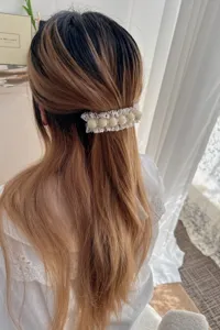 Detailed close-up view of sweet lace pearl hair barrette worn on half-up hairstyle.