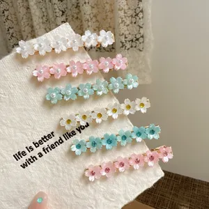 Close up of sweet floral hair clips set, featuring pearl and rhinestone accents on metal base.