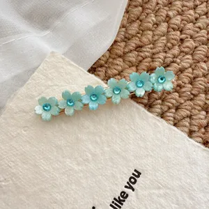 Close-up detail of sweet floral rhinestone side clip hair barrette in light blue tone.