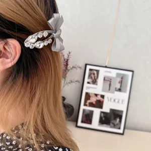 Close-up of a Korean sweet grey ribbon bow hair clip with sparkling rhinestones for women.