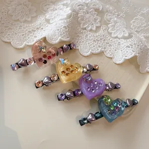 Close-up detail of sparkling rhinestone heart hair clips featuring colorful crystal and cute design.