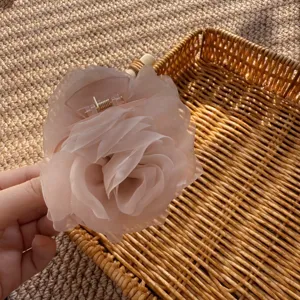 Exquisites Detail der rosa Netzrosen-Haarklammer mit weicher Blumenstruktur und Design.