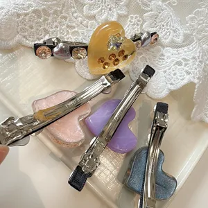 Close-up of Korean style cute heart rhinestone hair clips with resin and metal duckbill.