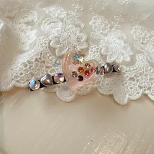 Sweet pink crystal heart hair clip featuring colorful rhinestones and delicate lace background.