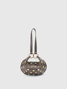 Close-up view of curved leather shoulder bag featuring polished golden dome studs and rings.