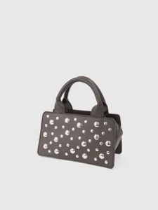 Detailed view of dark grey leather handbag with silver metallic stud embellishments.