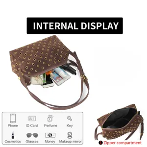 Detailed view of brown suede shoulder bag with metal grommets and interior zipper compartment.