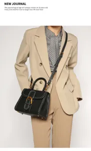Black vintage top handle crossbody bag with gold hardware and contrast stitching for women.