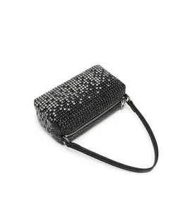 Rhinestone crystal embellished cylindrical evening shoulder bag with leather strap detail.