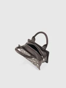Detail view of the dark brown punk style handbag with metallic rivet embellishments and zipper.
