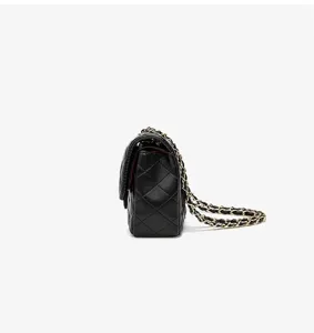 Detail view of black quilted leather crossbody bag with classic gold chain strap detail.