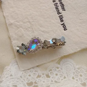 Exquisite rhinestone duckbill hair clip detail shot, featuring colorful crystal and bow design.