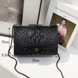 Black crocodile pattern crossbody bag with metal chain strap, compact size detail view.