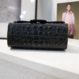 Close-up view of the black crocodile textured leather crossbody bag showing fine texture details.