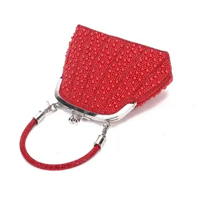 Elegant red beaded evening bag with metal kiss-lock closure and handheld strap for parties.
