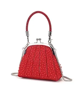 Exquisite red pearl kiss-lock evening bag detail, featuring sparkling rhinestones and chic chain.