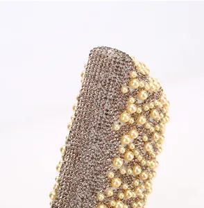 Detailed view of sparkling rhinestone evening bag surface embellished with elegant pearls.