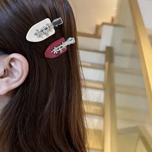 Detailed view of sweet hair clips with rhinestones and metal flowers, elegant hair accessories.