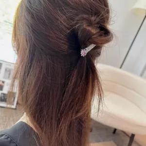 Elegante rechteckige Haarspange aus Metall mit Strasssteinen und rosa Kristall. Detailansicht.