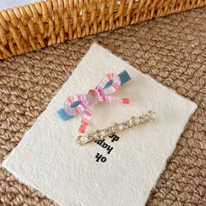 Sweet pink bow hair clip and sparkling rhinestone hairpin set, perfect for cute side hairstyles.