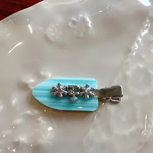 Details of turquoise striped rhinestone flower hair clip, cute duckbill clip for styling.