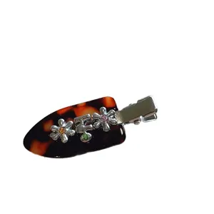 Tortoiseshell hair clip with floral rhinestone details and duckbill design for cute everyday wear.