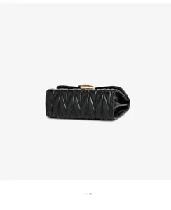 Black quilted leather mini crossbody bag with gold tone hardware detail for women.