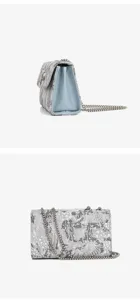 Detail view of stylish embroidered chain shoulder bag with metallic clasp and strap.