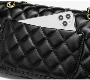 Quilted chain shoulder bag detail showing mobile phone pocket and premium black leather texture.