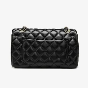 Detail view of black quilted leather crossbody bag with elegant gold chain strap design.