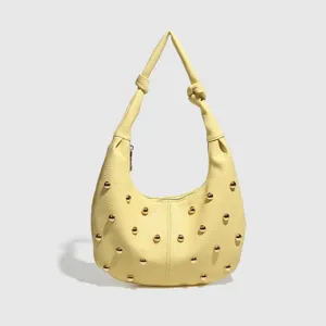 Stylish yellow shoulder bag for women with knot strap and chic metal studs design.