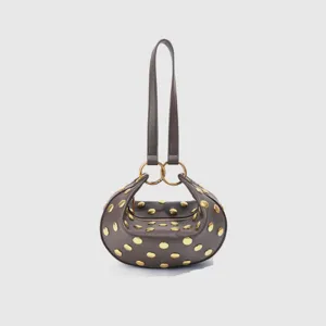 Retro PU leather shoulder underarm bag with gold rivets and unique curved design for women.