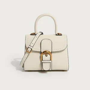 Elegant off-white leather top handle handbag with classic horseshoe metal buckle and strap.