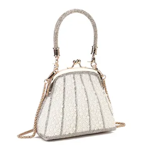 Close-up detail of elegant pearl-encrusted evening bag with sparkling rhinestone handle.