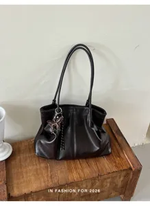 Vista dettagliata della borsa tote marrone retrò con ciondolo farfalla su scatola di legno.