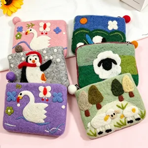 Details of handmade wool felt coin purses featuring cute animal and landscape designs with zippers.