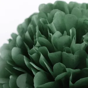 Close-up detail shot of a dark green paper pom pom flower for party decoration and backdrop.