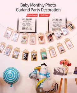 Detail view of baby first birthday photo garland banner and hanging frames for party decor.