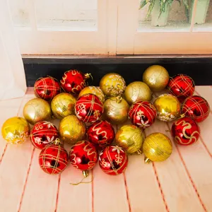 Close-up of 6cm plastic Christmas tree decorative balls with red and gold glitter painted designs.