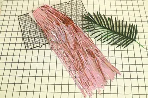 Detailed view of shiny pink foil fringe curtain, perfect for birthday party wall decoration.