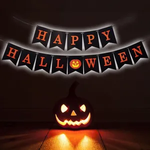 Halloween party decoration banner detail, black flags with orange letters and glowing pumpkin.