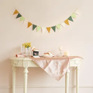 Glitter paper triangle bunting banner for birthday party decoration, green and gold party decor detail.