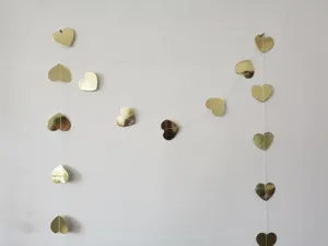 Detail view of the hanging gold heart paper garland, featuring reflective mirror finish surface.