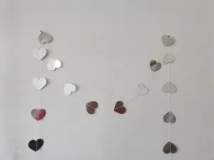 Mirror heart paper garland detail, reflective red and silver hanging decor for party.