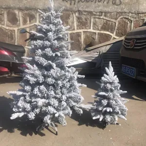 Albero di Natale artificiale floccato con neve, ideale per decorazioni festive.