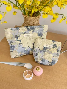 Detail shot of the embossed floral makeup bag, showing fine jacquard fabric and storage design.