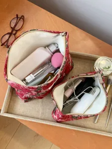 Detail view of retro red floral jacquard cosmetic bags, featuring neat interior storage design.