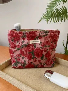 Vintage red floral jacquard cosmetic pouch detail, elegant makeup storage bag zipper.