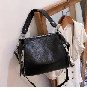 Close-up detail of black genuine leather women handbag, simple casual shoulder crossbody bag.
