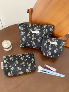 Floral cosmetic bag set detail view showcasing black makeup pouches with tulip print and zipper.